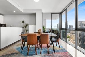 una sala da pranzo con tavolo, sedie e ampie finestre di Central 2-Bed with Parking & Stunning Views a Sydney