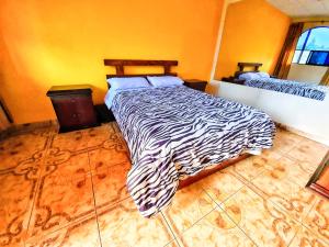 - une chambre avec un lit à motifs zébrés dans l'établissement Hostal La Cocha, à Latacunga