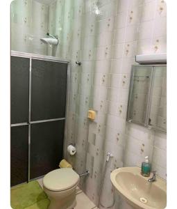 y baño con aseo y lavamanos. en Suíte com ar-condicionado (Família Hassan), en Corumbá