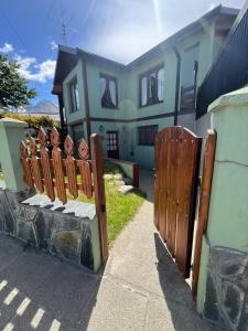 a wooden fence in front of a house at BZ Apartment in Ushuaia