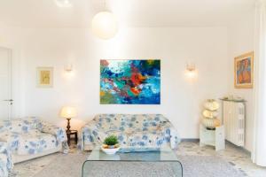 a living room with two couches and a painting on the wall at [Sea View] Appartamento Panoramico Wifi A/C in Porto San Giorgio