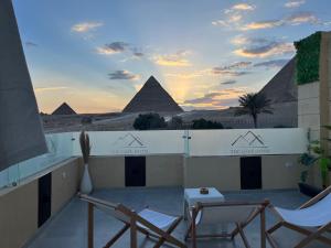 een uitzicht op de piramides vanaf het balkon van een gebouw bij The Gate Hotel Front Pyramids & Sphinx View in Caïro