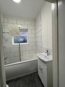 a white bathroom with a tub and a sink at Private double rooms near City centre, Coventry with free Parking/WiFi in Coventry