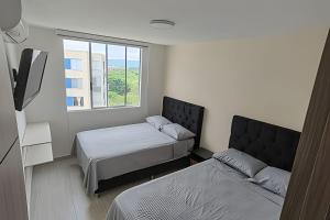 a bedroom with two beds and a window at Apto completo Pto Azul Club House Ven a Descansar in Ricaurte +52 photos