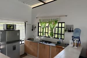 a kitchen with a refrigerator and some windows at Hermosa finca plan ecológico Brisas de 4 Esquinas in Carmen de Apicalá