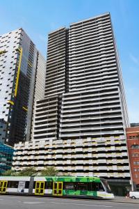 a train in front of a large building at Complete Host NEO apartments in Melbourne