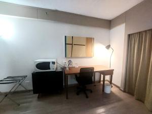 Zimmer mit einem Schreibtisch, einem Computer und einer Mikrowelle. in der Unterkunft Flat Borges Lagoa Vl Mariana Ibirapuera com garagem UH1007 in São Paulo