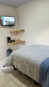 1 dormitorio con 1 cama y TV en la pared en Cozy and Private Monteverde, en Monteverde