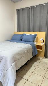 1 dormitorio con 1 cama grande con almohadas azules en Cozy and Private Monteverde, en Monteverde