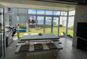 Sala de estar con mesa y vistas al océano en Marina View, en Jeffreys Bay