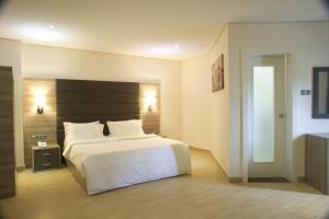 una camera con letto bianco e testiera nera di Scarlet Lodge a Lagos