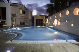 a swimming pool in front of a building at night at Scarlet Lodge in Lagos