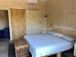 una camera da letto con un letto grande con un copriletto bianco di Casa Taller a Lo de Marcos