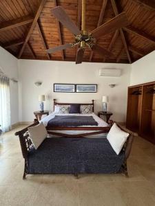 1 dormitorio con 1 cama grande y ventilador de techo en Villa Beach & Golf CASA DE CAMPO, en La Romana