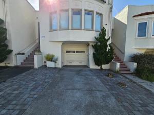 une maison blanche avec un garage et une allée dans l'établissement Sunset location 2Bed/1Bath Apt close to Golden Gate Park, à San Francisco