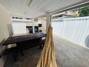 a porch with a wooden bench and a hammock at Morada do Mar Arraial do Cabo in Arraial do Cabo