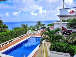 a swimming pool with a view of the ocean at 2BR 1BA, Modern Apartment with Aircon and Pool House Access in Harris