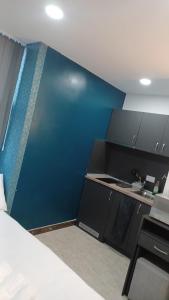 una pequeña cocina con una pared azul en Contractors Accomodation, en Sunderland