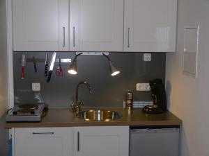 a kitchen counter with a sink and white cabinets at Business Flat Bahnhofstraße in Wiesbaden