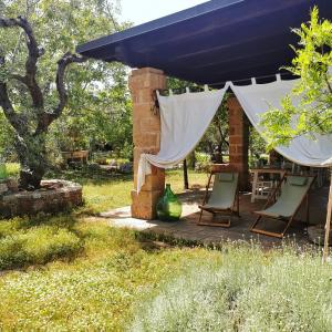 un patio con sillas y un dosel azul en Masseria Borgo del Gallo, en Tricase