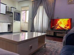 uma sala de estar com televisão e lareira em Stylish & Convenient Condo for couples and familes em Addis Ababa