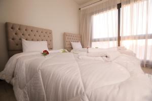 a bedroom with two beds with white sheets and a window at Duplex-Nyoum New Cairo in Cairo
