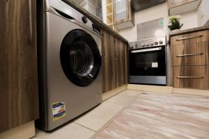 a laundry room with a washing machine in a kitchen at Duplex-Nyoum New Cairo in Cairo +64 photos