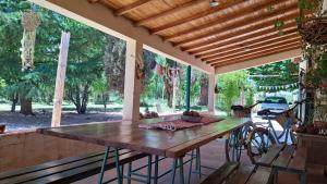 una mesa de madera en un pabellón con una gran ventana en Aire de Barreal Hostel Andino en Barreal