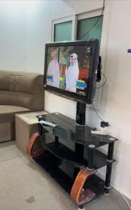 einen TV auf einem Tisch im Wohnzimmer in der Unterkunft شاليه 1 in Al Ḩazm