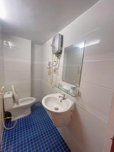 W łazience znajduje się toaleta, umywalka i lustro. w obiekcie Golden Hotel w Ho Chi Minh