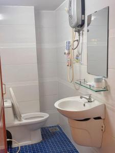 W łazience znajduje się toaleta, umywalka i lustro. w obiekcie Golden Hotel w Ho Chi Minh