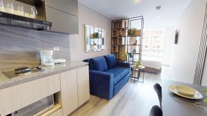 uma sala de estar com um sofá azul numa cozinha em Your Home in the Heart of Bogotá em Bogotá