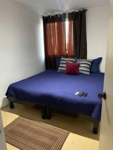 Schlafzimmer mit einem Bett mit lila Bettwäsche und Kissen in der Unterkunft Casa ideal con cochera, seguridad y céntrica in Mazatlán