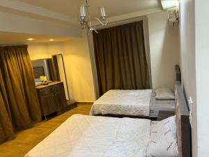a hotel room with two beds and a dresser at 4شارع نبلس المهندسين in Cairo