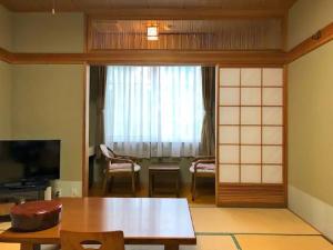 een woonkamer met een tafel en een raam bij Koguriyama Sanso - Vacation STAY 43384v in Minami Uonuma