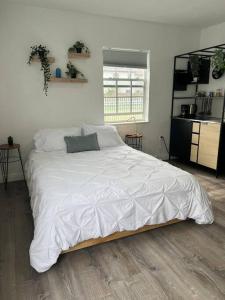 1 dormitorio con 1 cama grande con sábanas blancas en Nice and Cozy guest house 4, en Miami