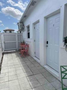 a white house with two doors and a table on a patio at Nice and Cozy guest house 4 in Miami