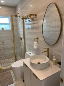 een badkamer met een wastafel, een toilet en een spiegel bij Nice and Cozy guest house 4 in Miami