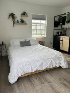 een slaapkamer met een groot bed met witte lakens bij Nice and Cozy guest house 4 in Miami