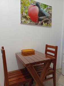 een houten tafel en stoel met een vogel op een schilderij bij Teresita's House Suites 2 con cocina privada in Puerto Baquerizo Moreno