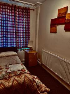1 dormitorio con 1 cama y 1 mesa con lámpara en Transformative housing birrell road en Nottingham