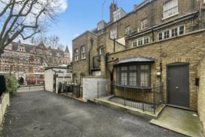 an empty parking lot in front of a brick building at Little Venice Maisonette in London