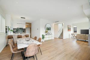 a dining room and living room with a table and chairs at Devonport Beach Front Home in Auckland