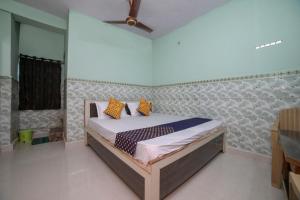 a bedroom with a bed with orange pillows on it at SPOT ON Hotel Ramgiri in Rāmtek