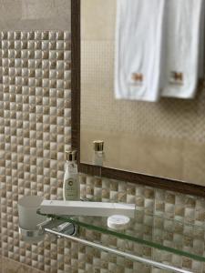 a bathroom with a glass counter with a mirror and a sink at MFAPARTMENT in Al Budayyiâ€˜