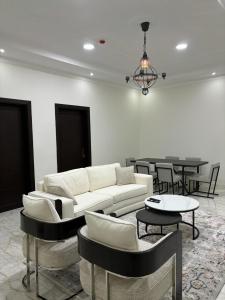 MFAPARTMENT في Al Budayyiâ€˜: غرفة معيشة مع أريكة وكراسي وطاولات