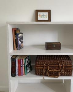 un estante con una cesta y libros y una caja en Totem en Mar del Plata