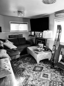 uma sala de estar com um sofá e uma televisão em SEAS THE DAY Hottub Pets LOCATION beaches dining 10 star em Gibsons