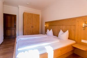 Un dormitorio con una cama grande con cabecero de madera. en Ferienland Stubai, en Fulpmes