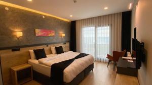 a bedroom with a large bed and a television at YASON BLUE SUIT OTEL in Perşembe